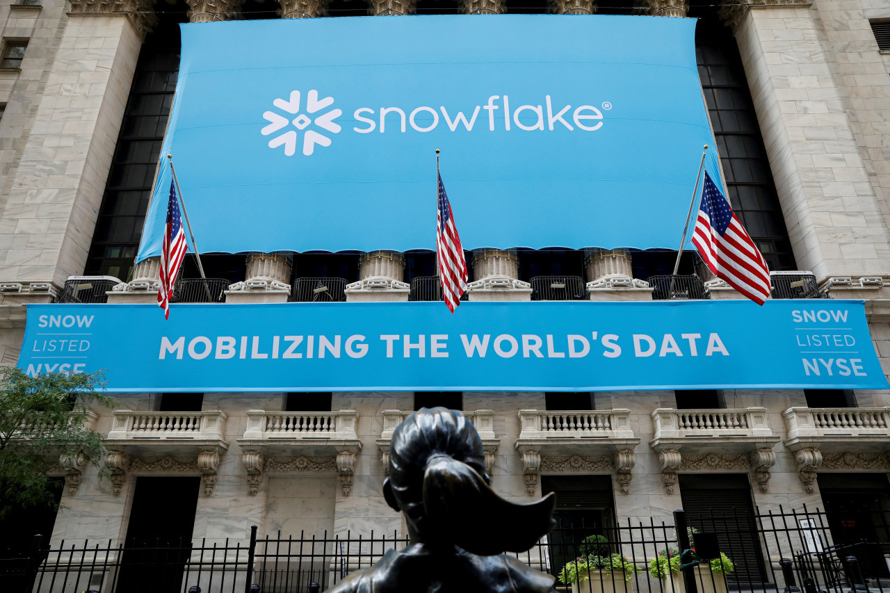 A large blue banner displaying the Snowflake logo and the slogan "Mobilizing the World's Data" is hung on the facade of a building, which is decorated with Amer