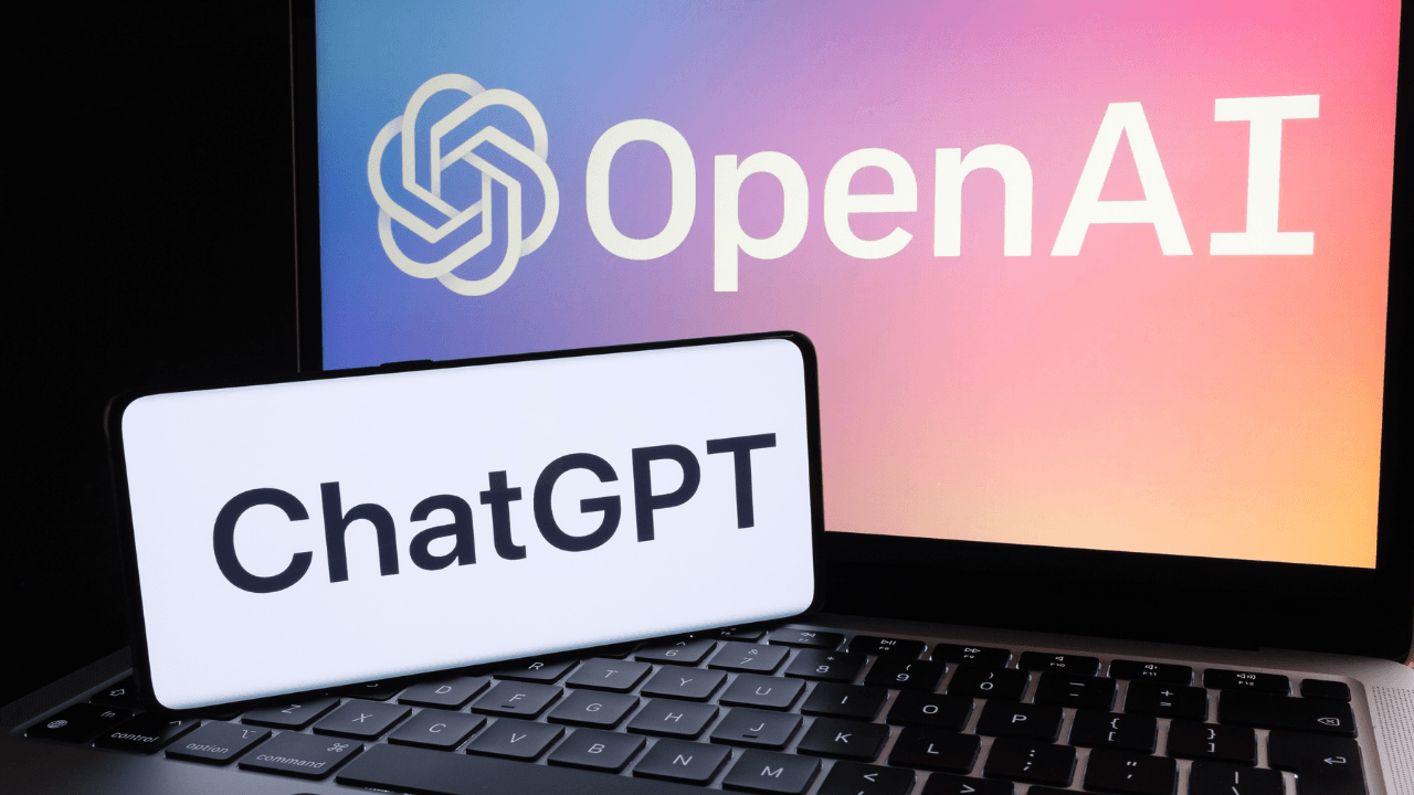 A laptop with a screen displaying the OpenAI logo and branding, alongside a sign that reads "ChatGPT," highlighting the competition from OpenAI's ChatGPT over p